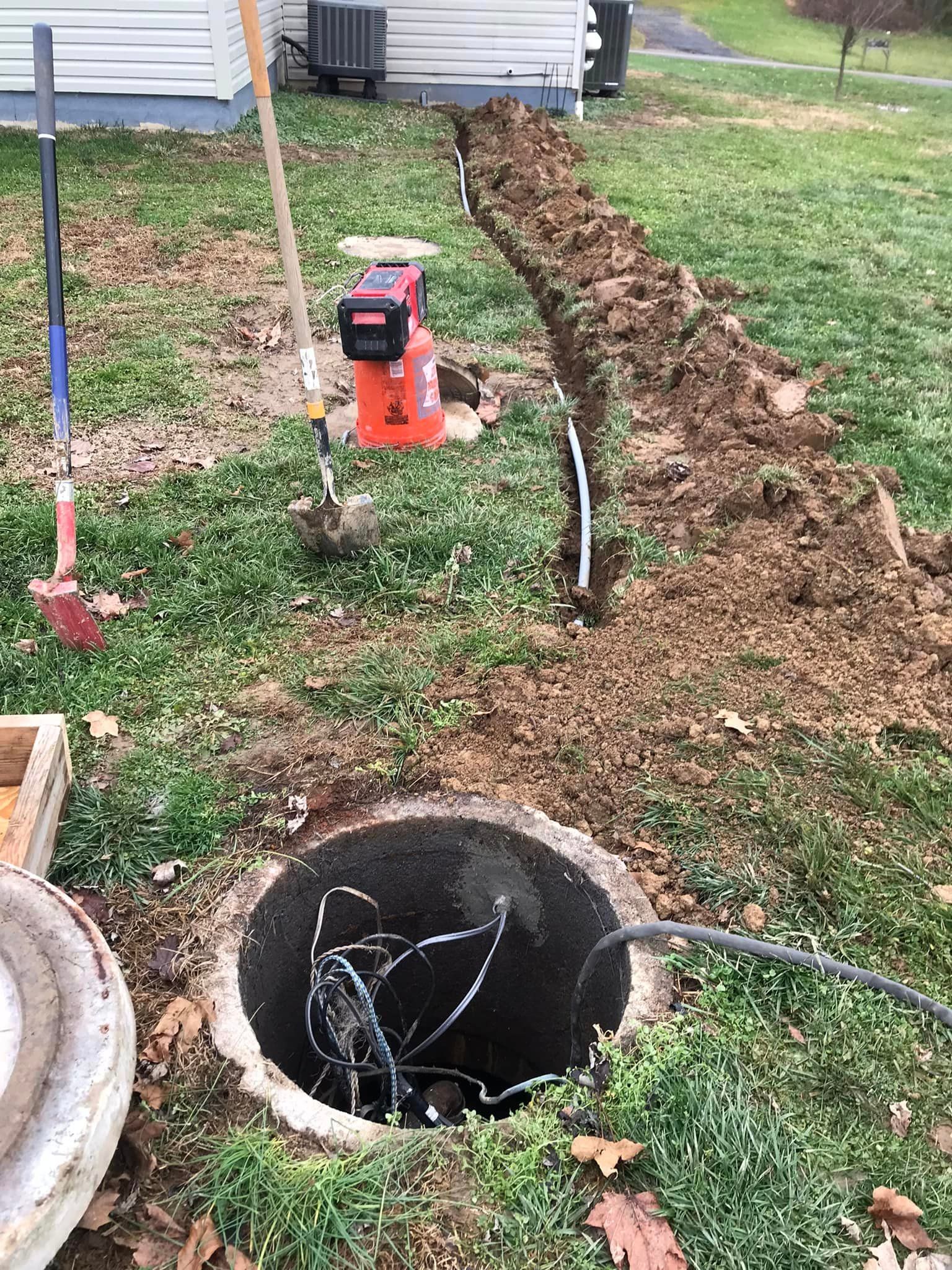 a manhole cover is being installed in a yard next to a house .