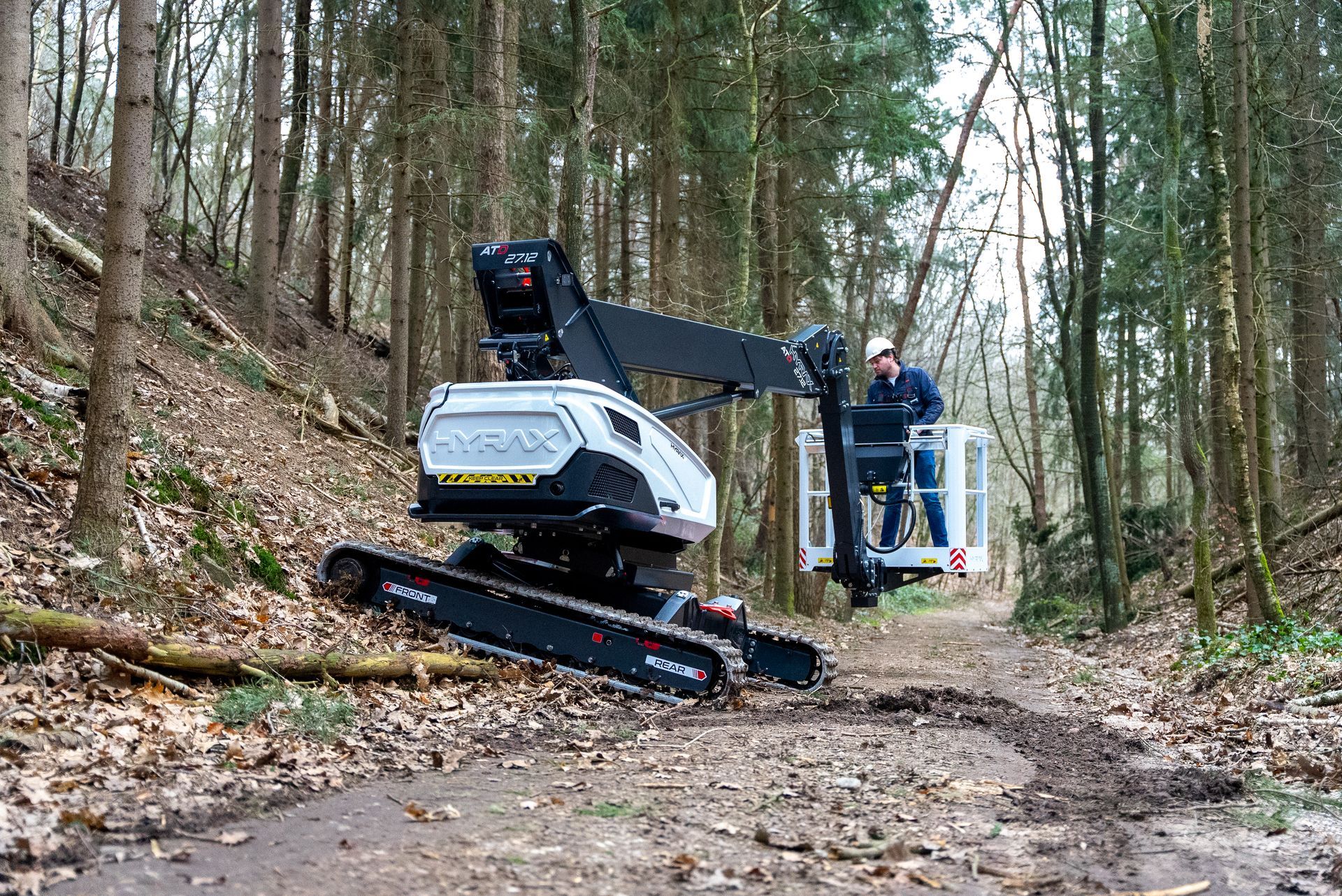 A man is riding a crane in the woods.