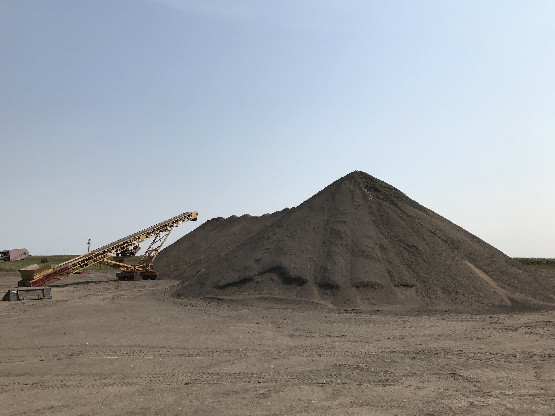 A large pile of dirt is sitting in the middle of a dirt field.