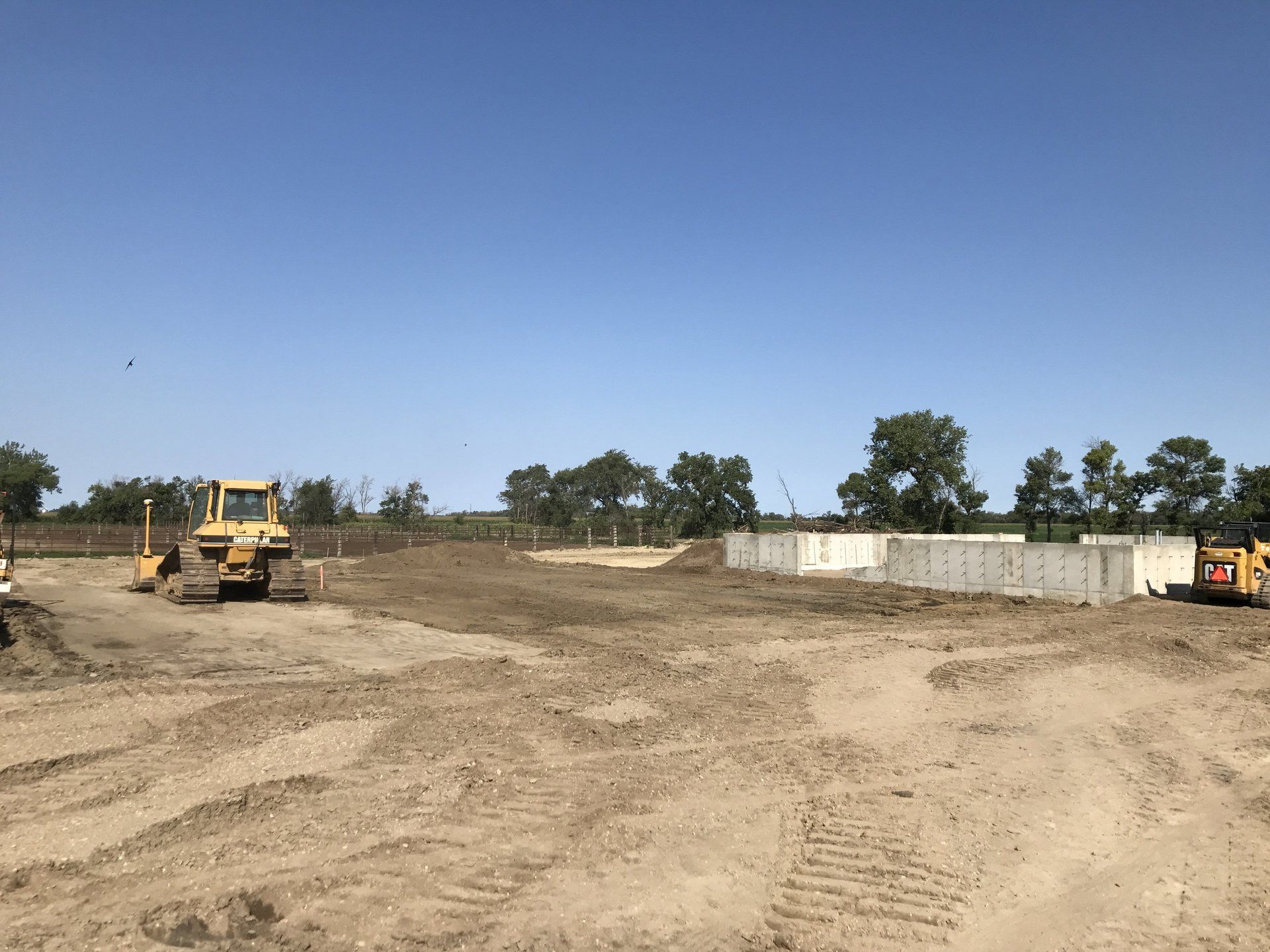 A bulldozer is sitting in the middle of a dirt field.