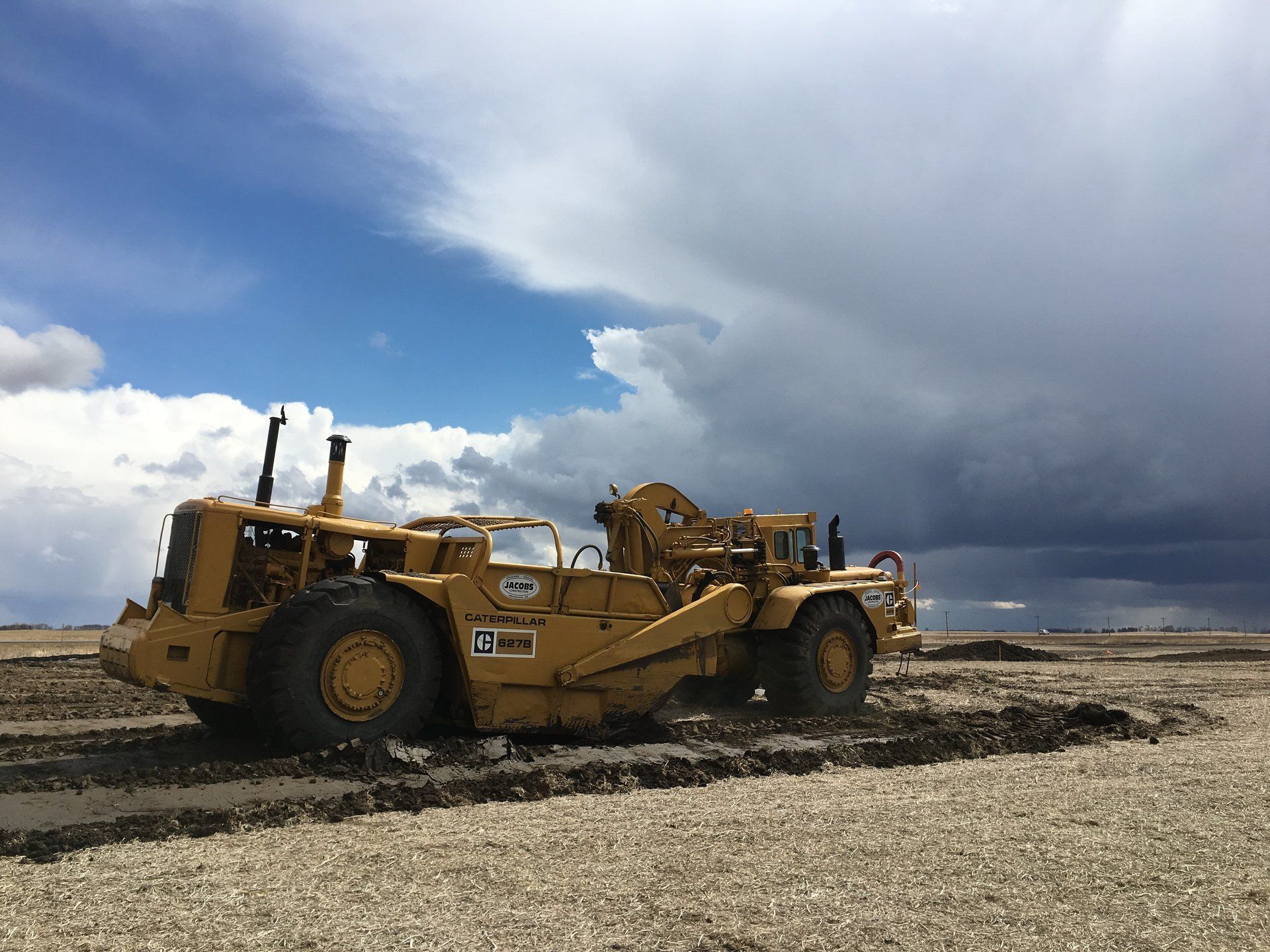 A bulldozer is sitting in the middle of a dirt field.