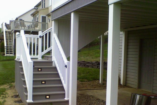 A deck with stairs leading up to it and a white railing