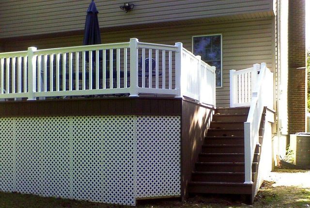 A deck with stairs leading up to it and a white railing
