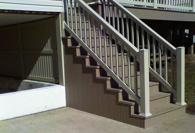 A set of stairs leading up to a deck with a white railing