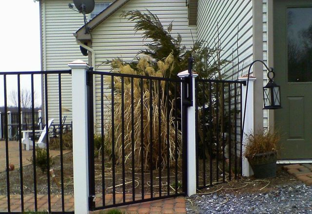 A fence with a gate in front of a house