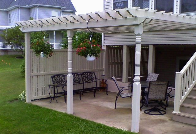 A pergola with a table and chairs underneath it