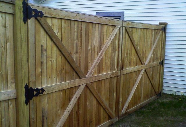 A wooden fence with a white house in the background