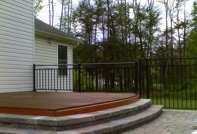 A white house with a wooden deck and stairs