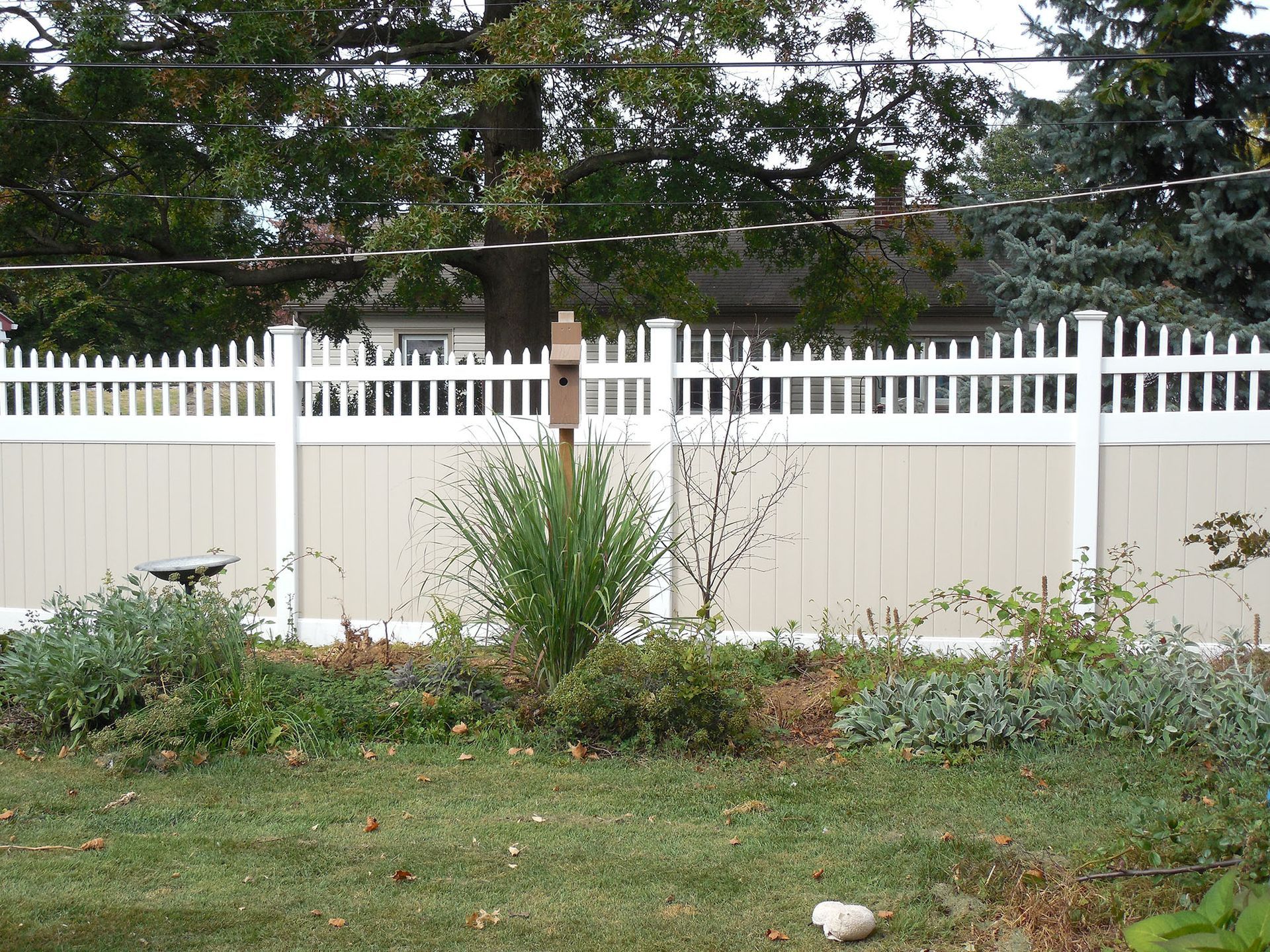A white picket fence surrounds a lush green yard