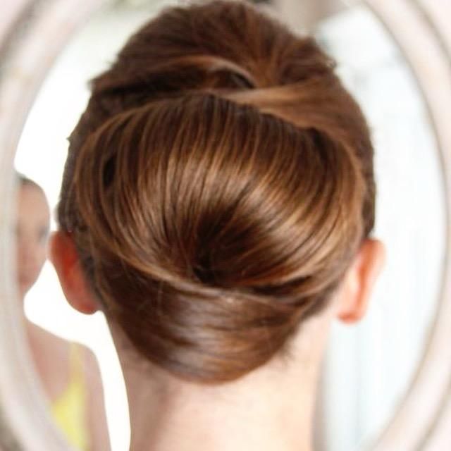 A woman is looking at her hair in a mirror