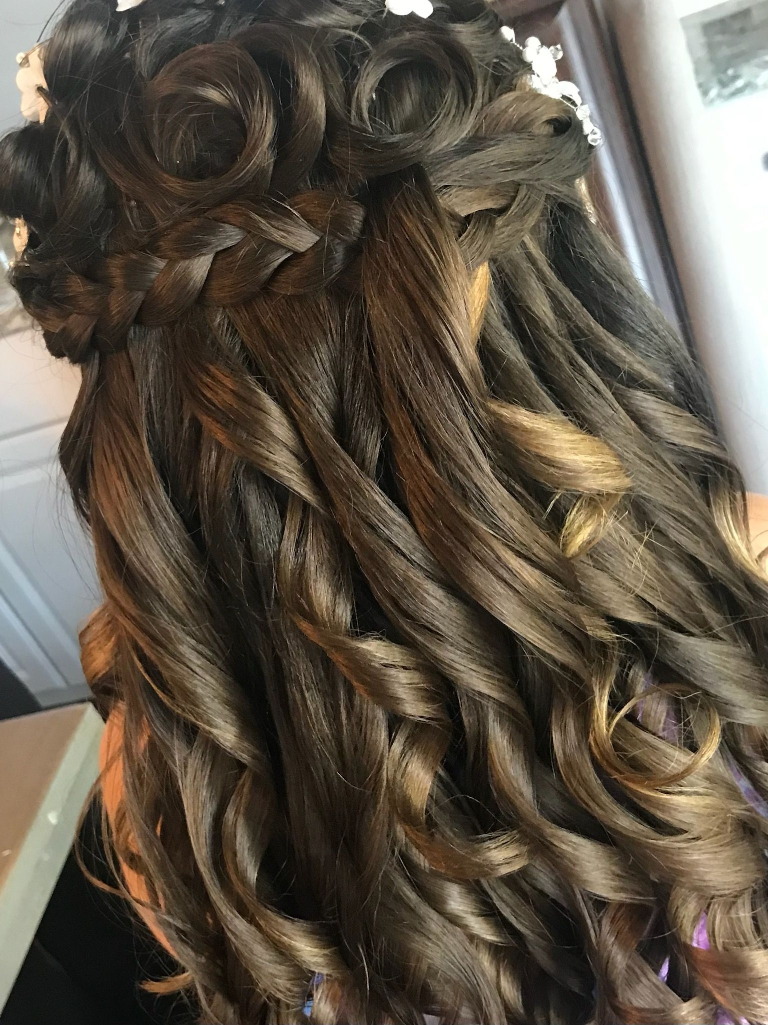 A close up of a woman 's hair with a flower in it.