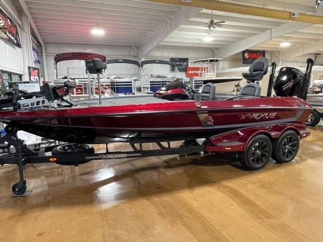 Red and black fishing boat on a trailer, inside a showroom.