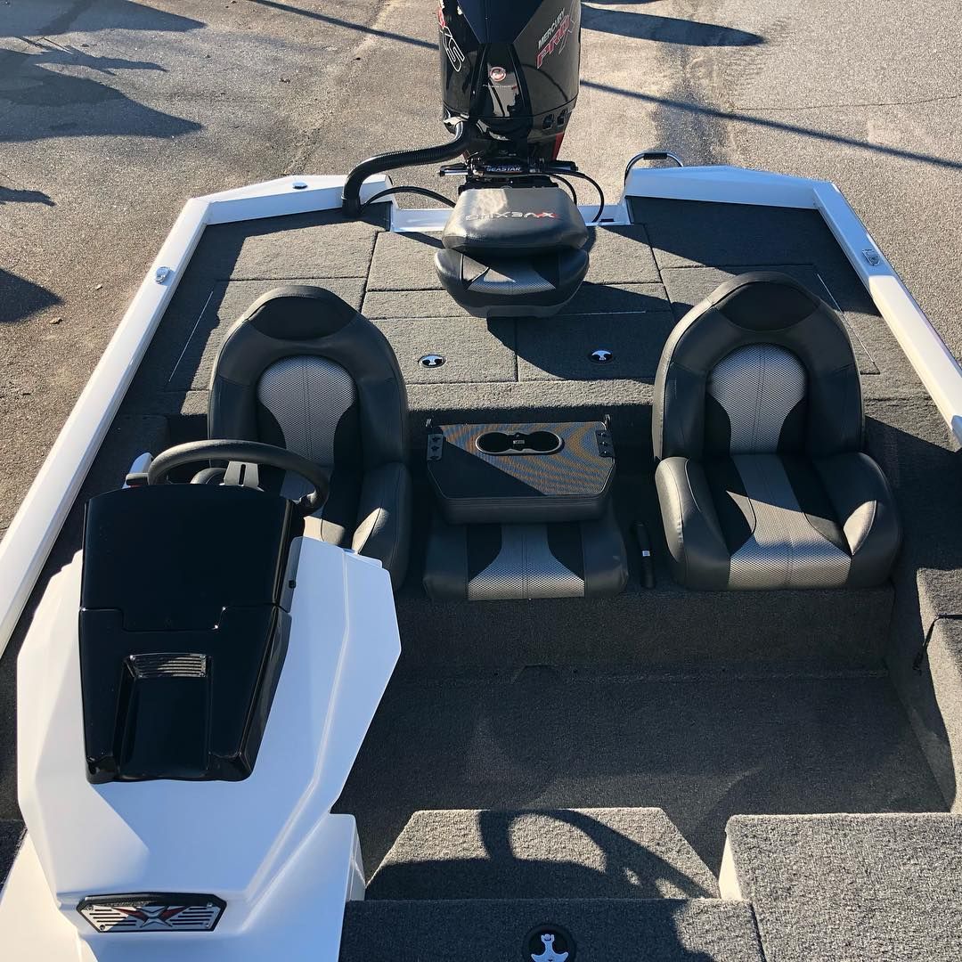 Bass boat with black and gray seating, steering wheel, and outboard motor.