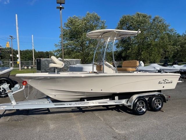 Tan Sea Chaser boat on a trailer, under a sunny sky.