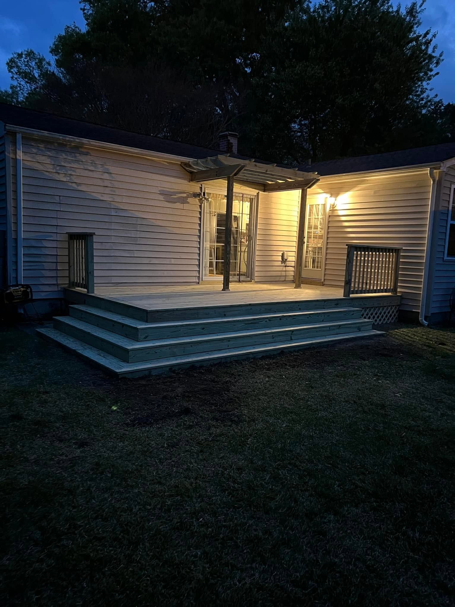 Lit porch of a small house at night with steps leading up to the entrance