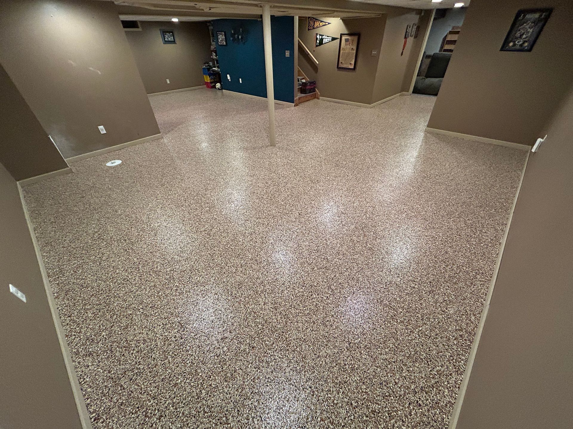 Wide lobby with speckled terrazzo floor, beige walls, and doors leading to hallways.