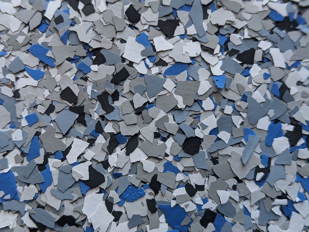 Blue, gray, and black confetti-like paper pieces scattered across a surface