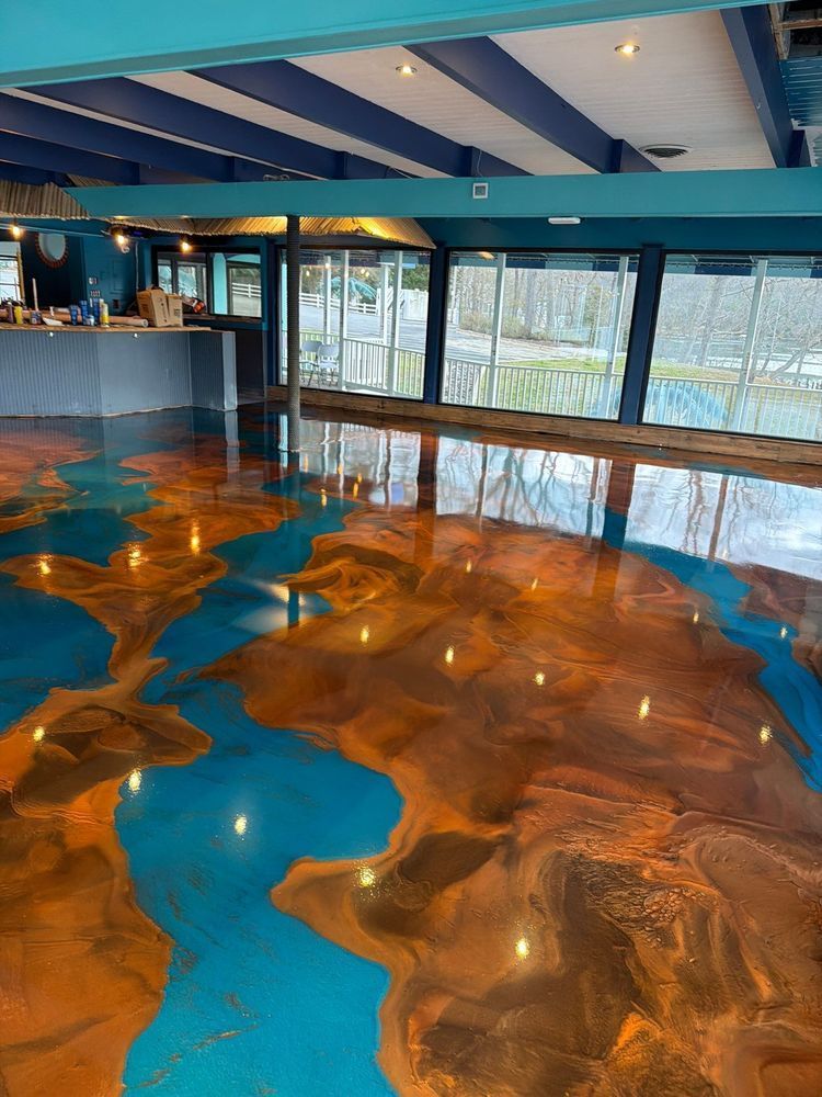 Glossy blue and amber resin floor in a modern room with large windows and a bar counter