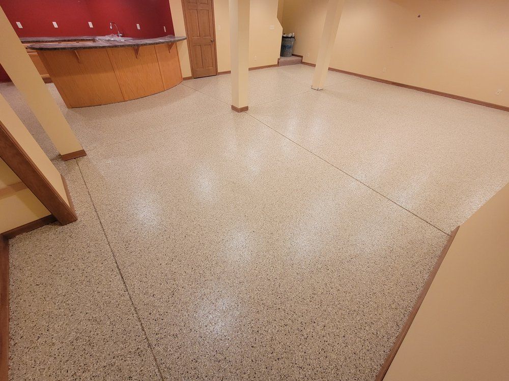 Empty lobby with speckled tile floor, beige walls, and a red reception counter.