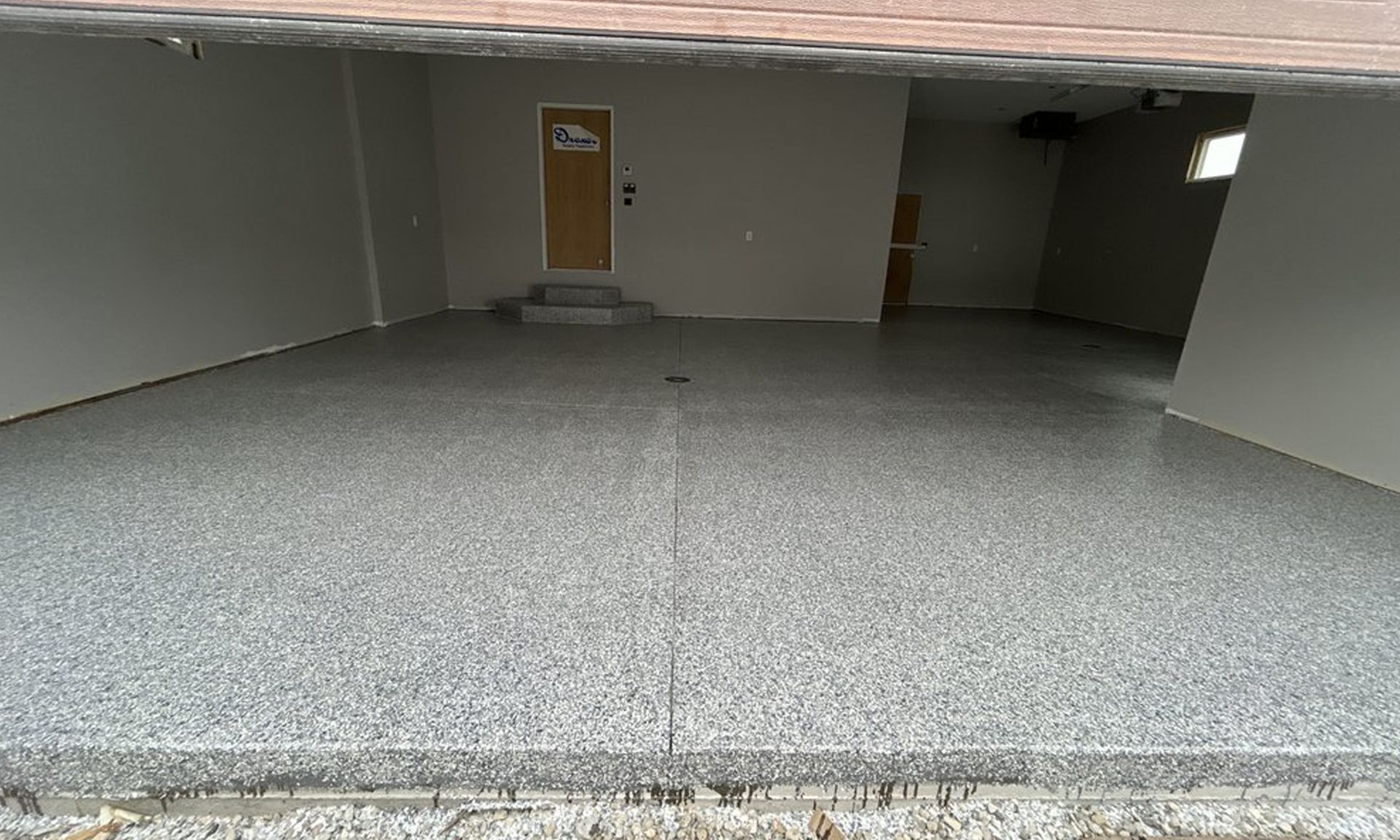 Empty concrete parking area with a single door at the back wall.