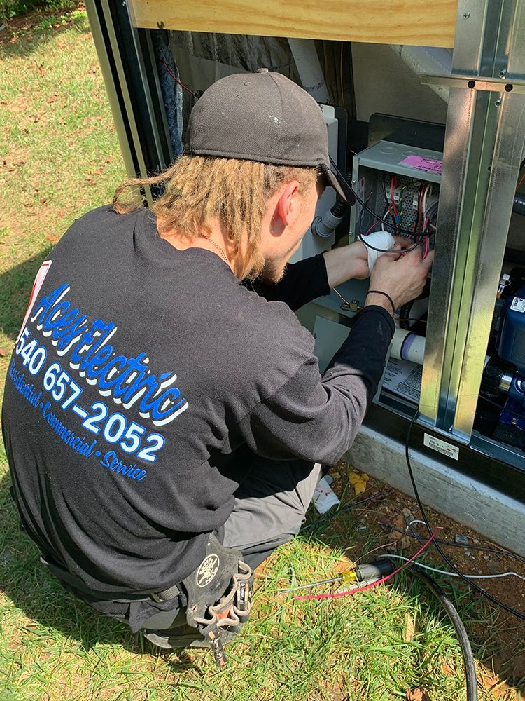 Man in black shirt working on electrical components outdoors.