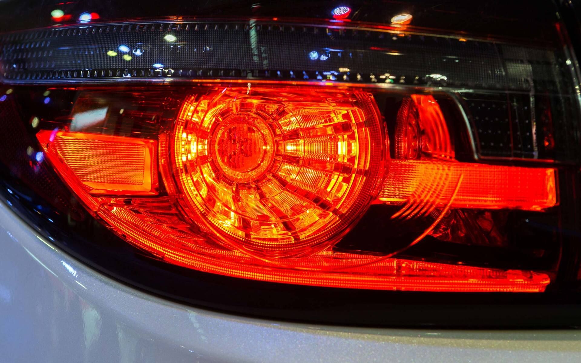 Close-up of a car’s red illuminated taillight at night