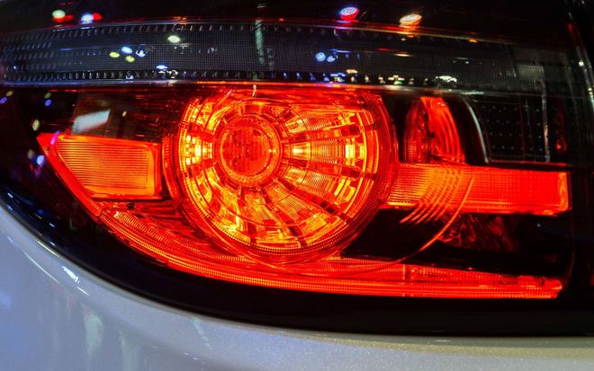 Close-up of a car’s red illuminated taillight at night