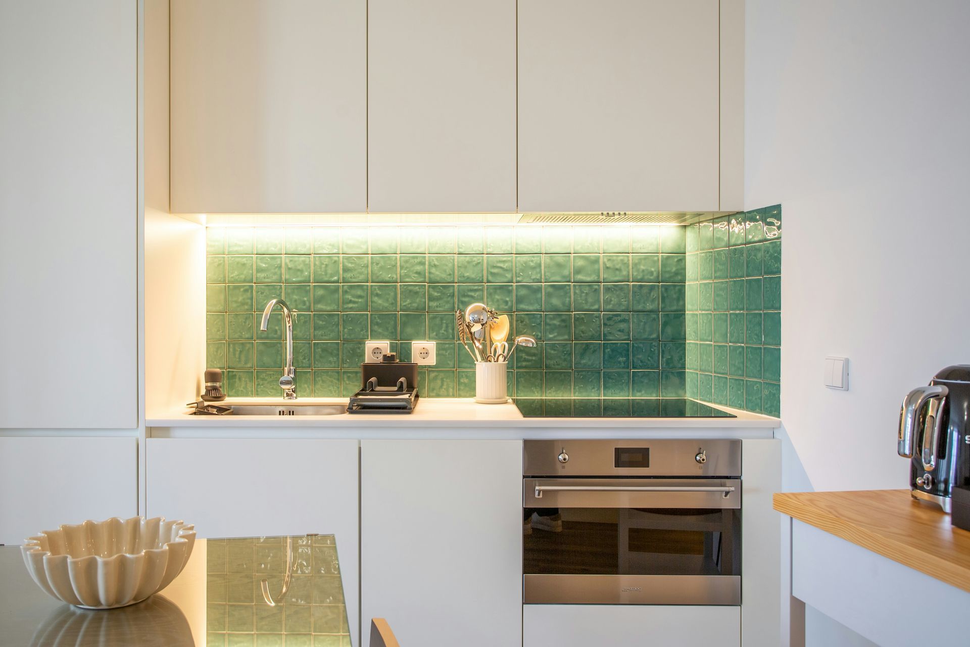 A kitchen with wooden cabinets, granite counter tops and stools.