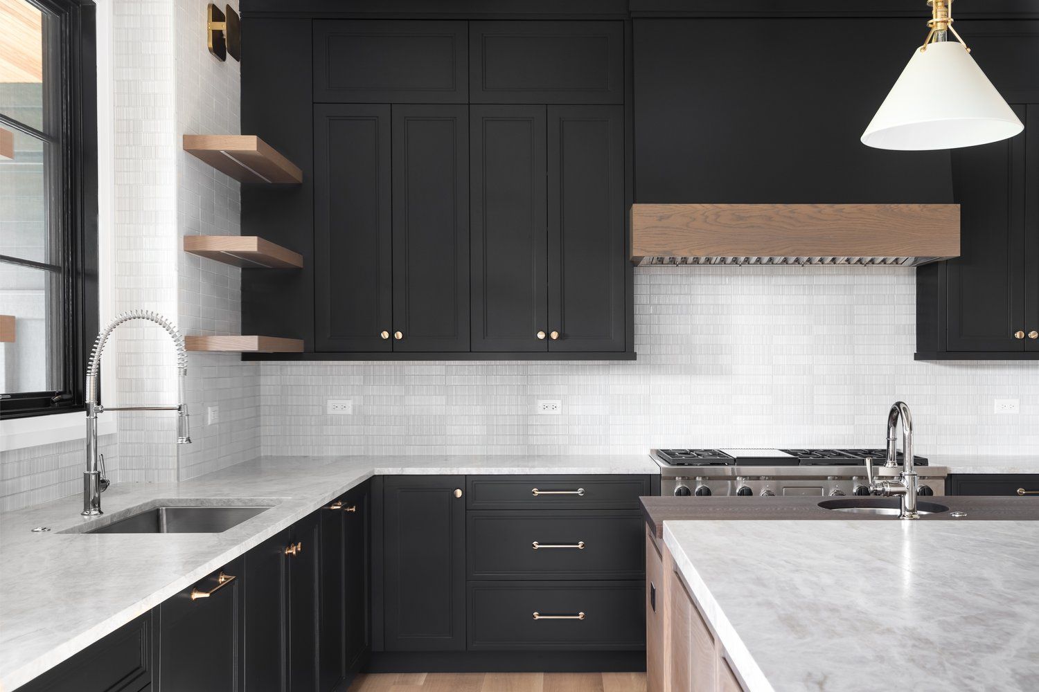 A kitchen with wooden cabinets, granite counter tops and stools.