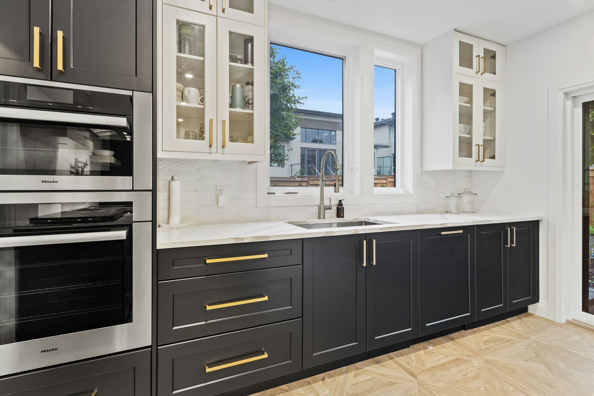 A kitchen with wooden cabinets, granite counter tops and stools.