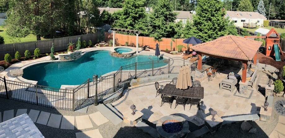 Backyard with a swimming pool, spa, gazebo, patio, and playground. Lush green trees surround the area.