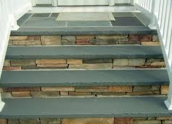 Stone steps leading up to a door. Slate treads and stone risers in a home exterior.