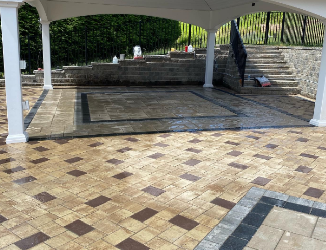 Patio with tiled floor and gazebo, stone retaining wall, and steps.