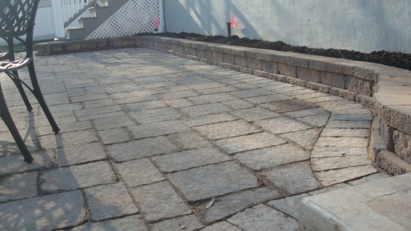 Brick patio with stone retaining wall.
