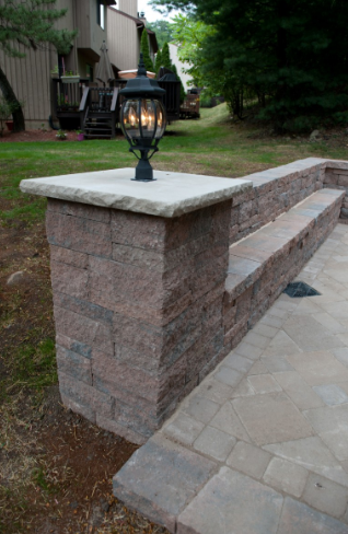 Brick retaining wall with steps, topped with a stone slab and decorative lantern.