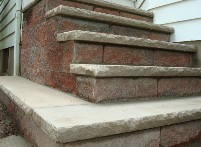 Red brick steps leading to a building, with light-colored stone edging.