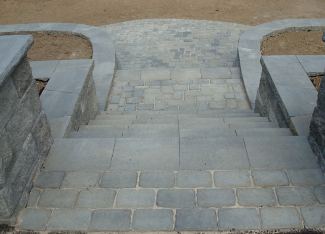 Stone steps with gray pavers and brick detailing, leading downwards.