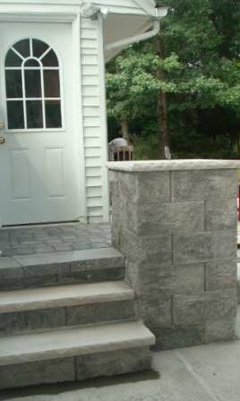 Stone steps leading up to a white door, with a matching stone pillar to the right.