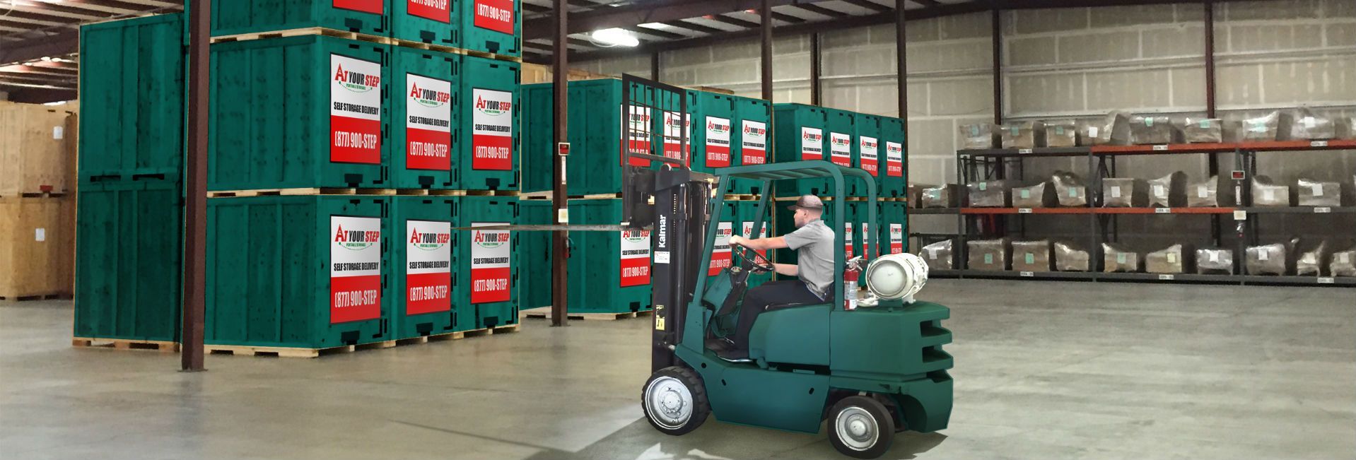 Warehouse worker driving a teal forklift past stacked green shipping containers in a large storage facility