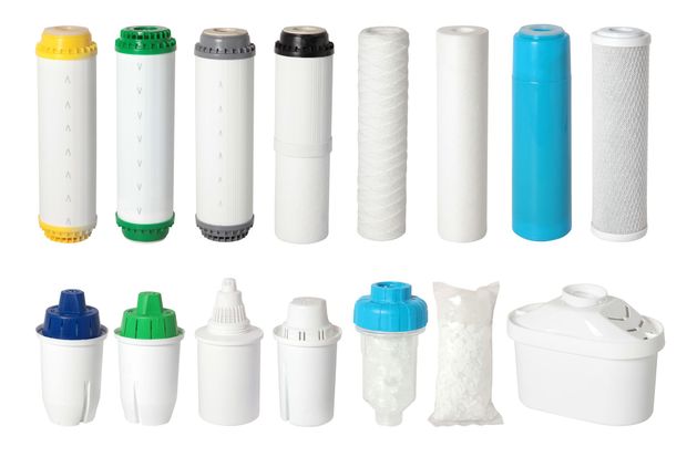 Assorted water filter cartridges and housings in white, blue, green, and black, arranged in two rows