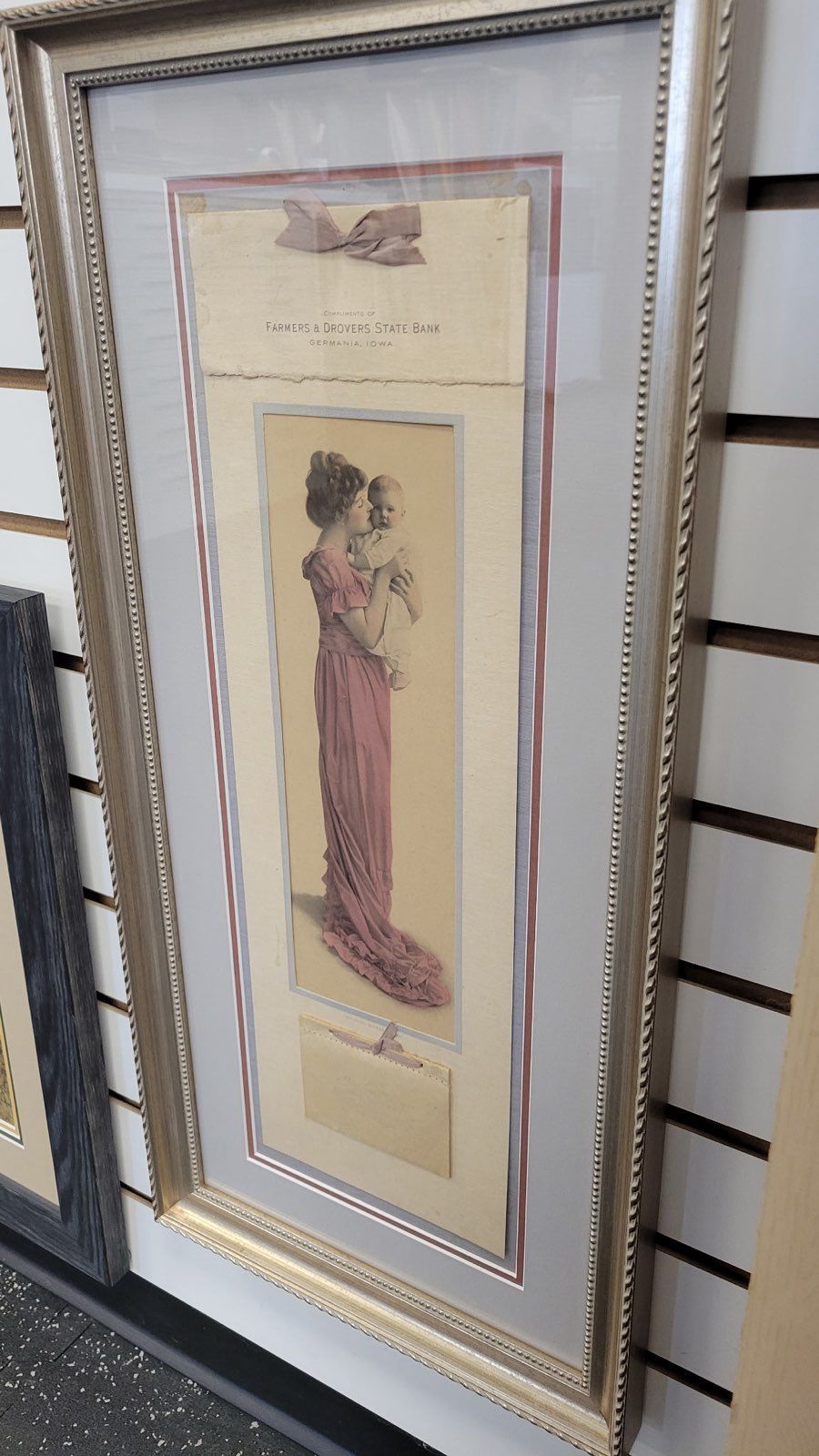 A framed picture of a woman in a pink dress