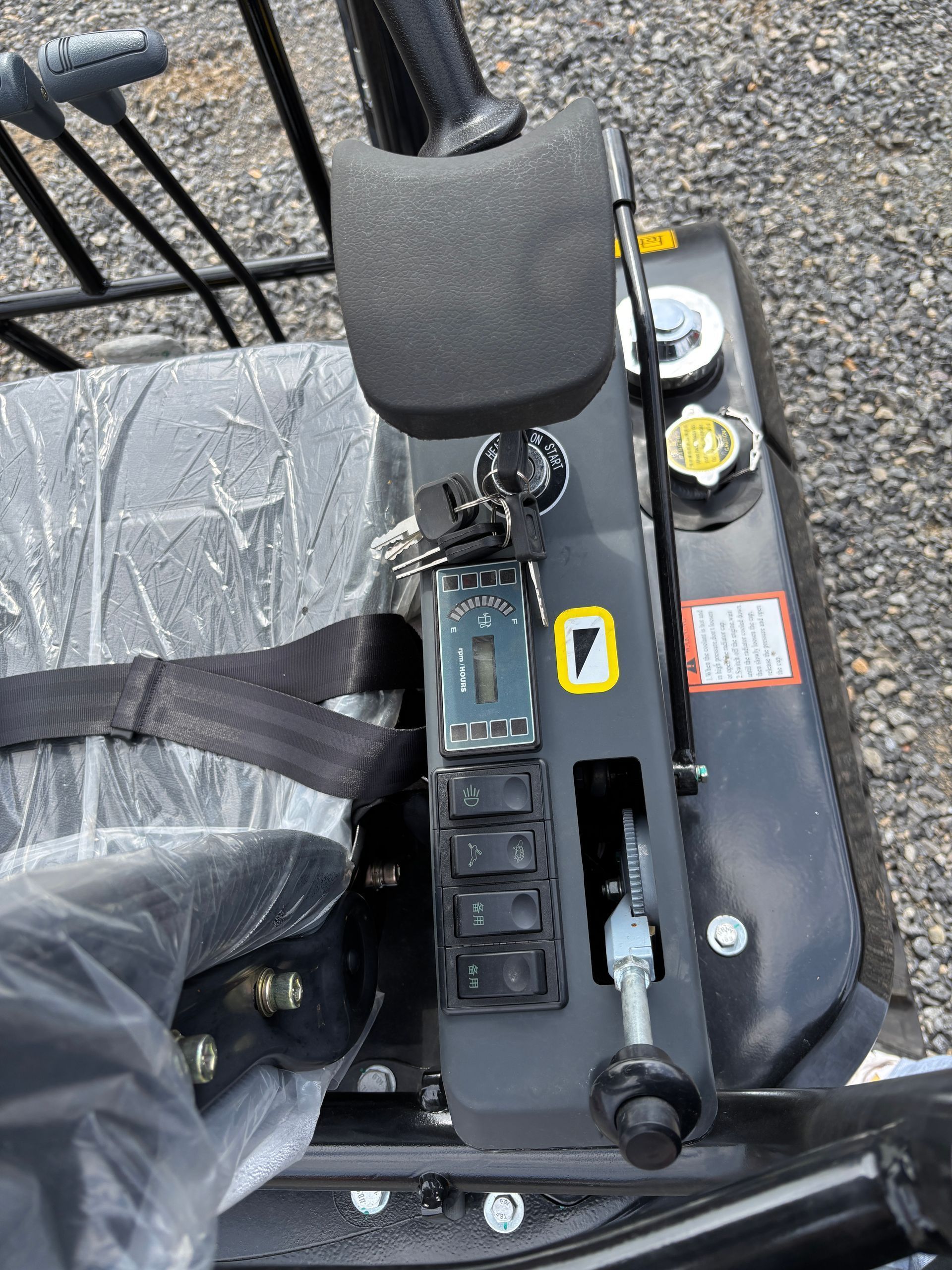 The controls of a zero-turn mower, including a key ignition, throttle lever, switches, and a cushioned seat.