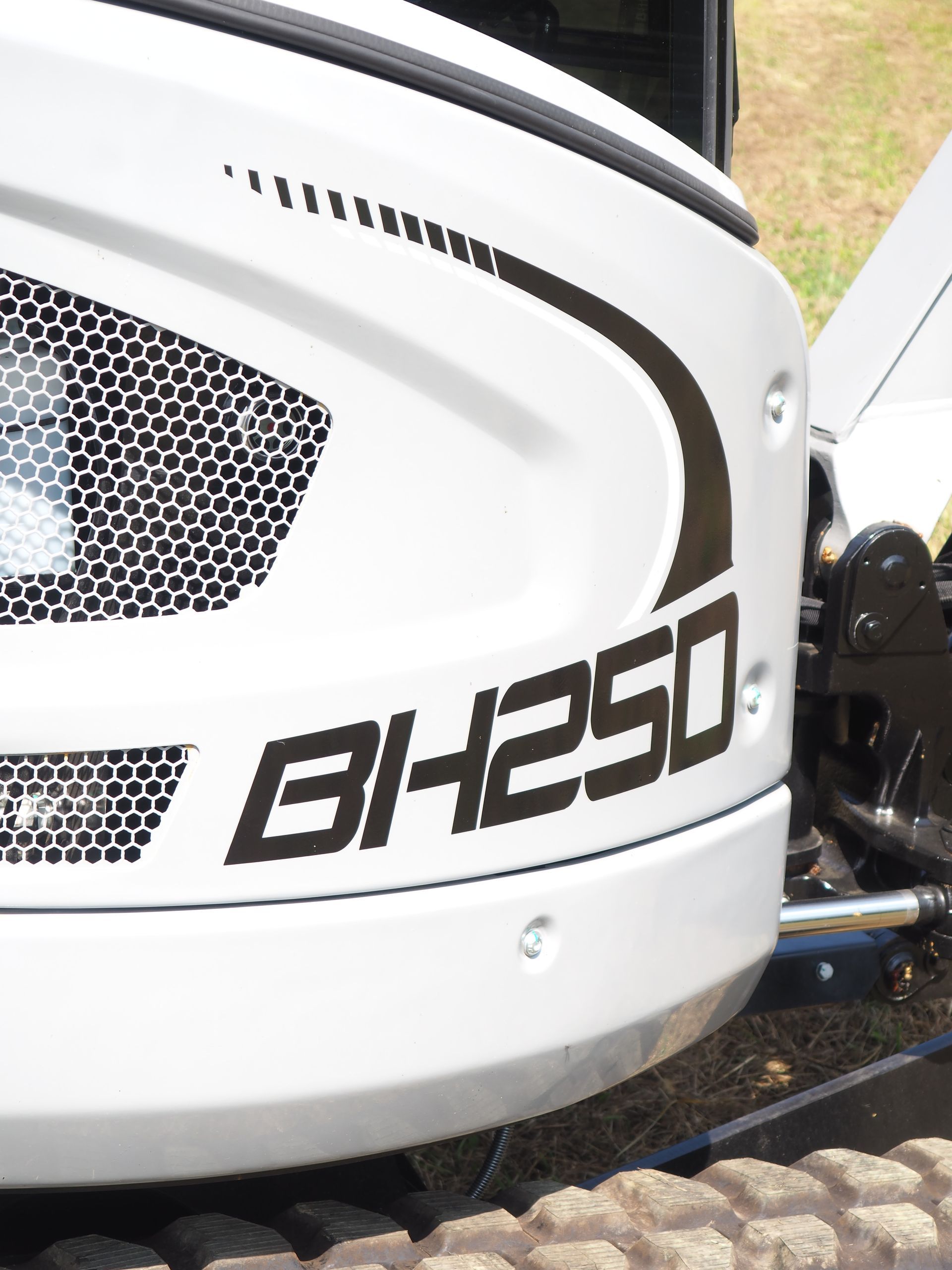 Close-up of a white construction vehicle body panel with the black model text 