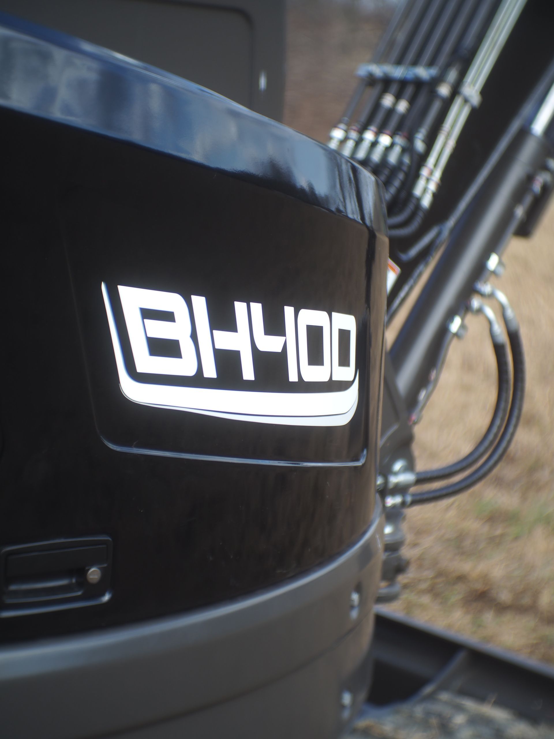 Close-up of a black excavator body with the white 