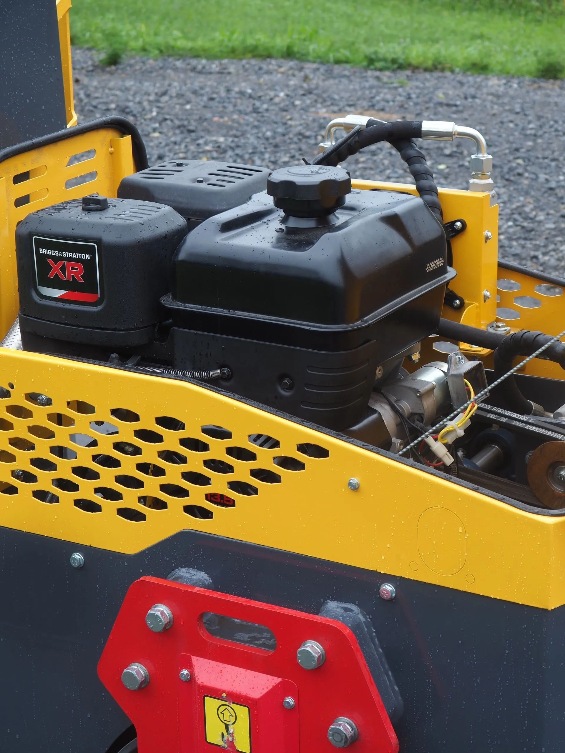A close-up of a yellow construction machine engine with a black fuel tank and an air filter labeled 