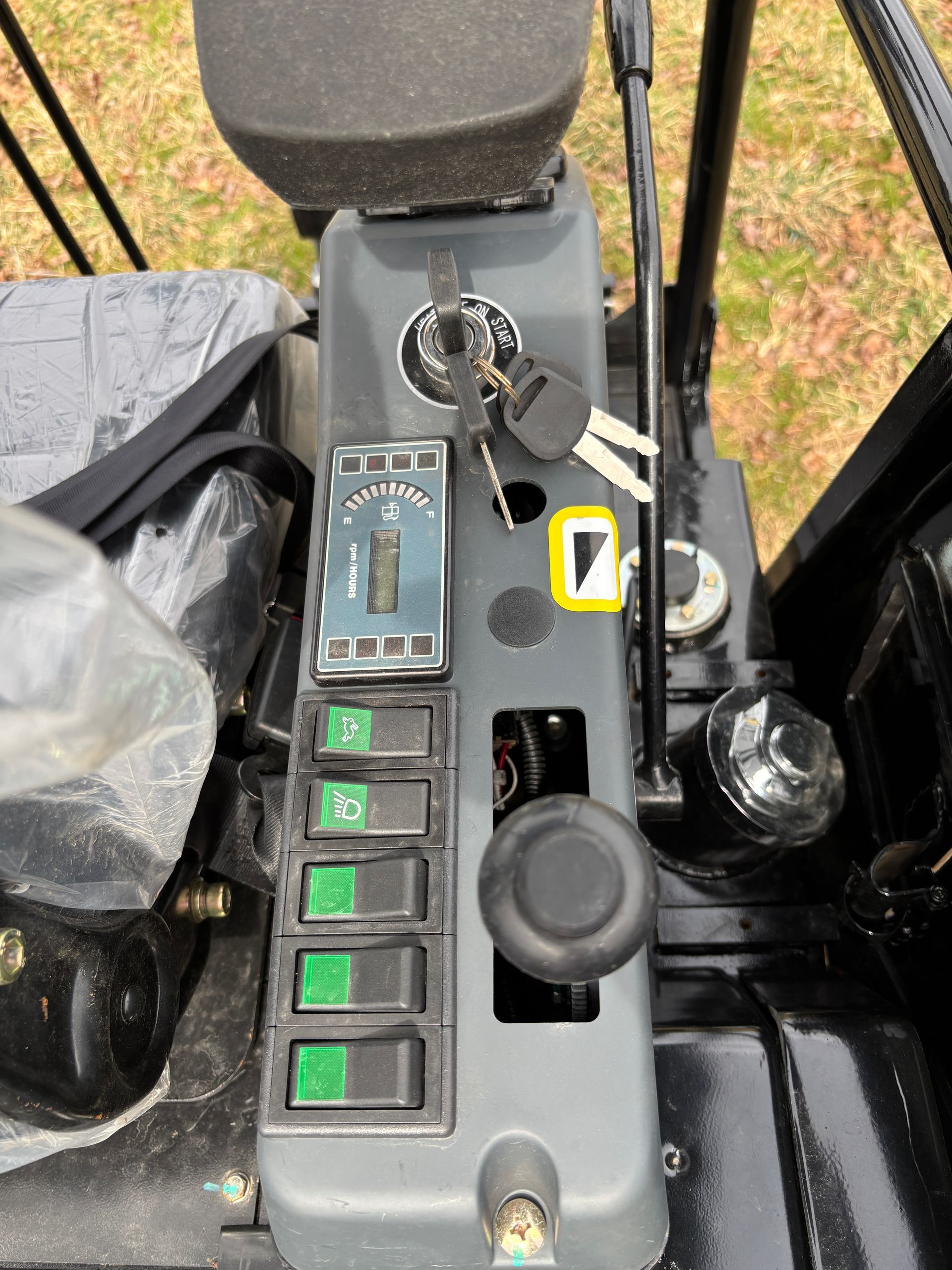 The operator's console of machinery featuring a key ignition, several rocker switches, and a control lever.