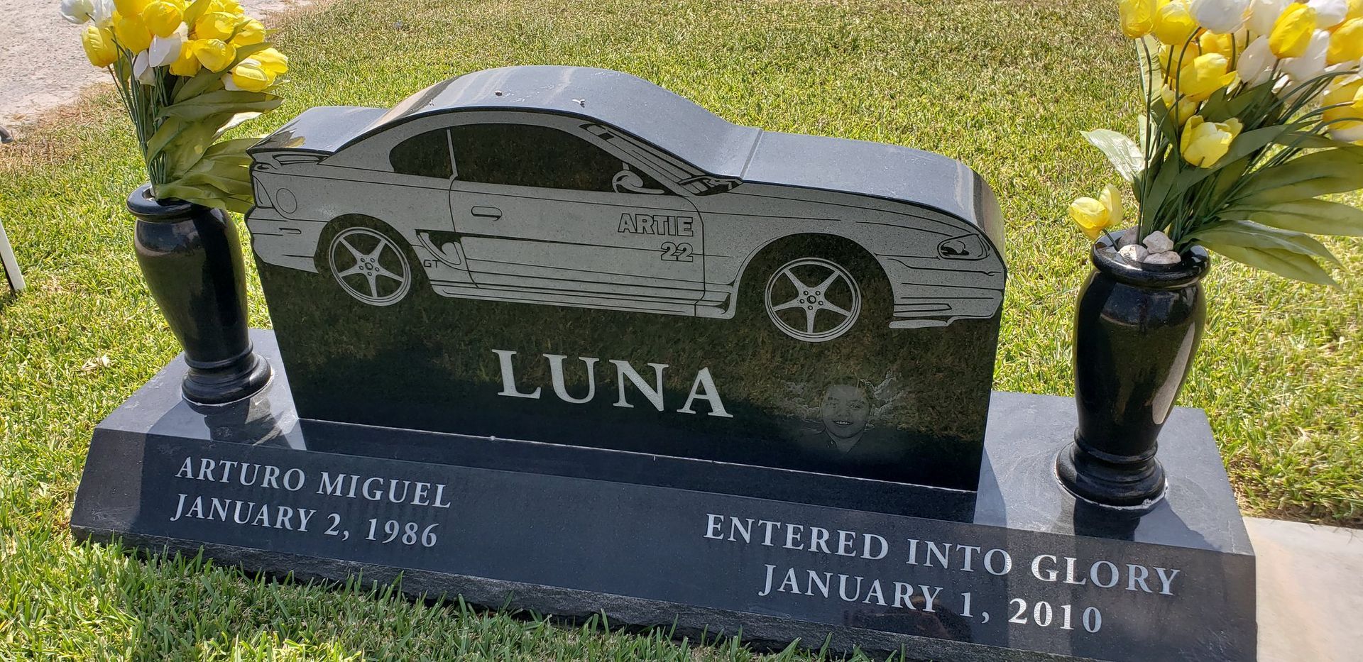 A gravestone for luna with a car on it