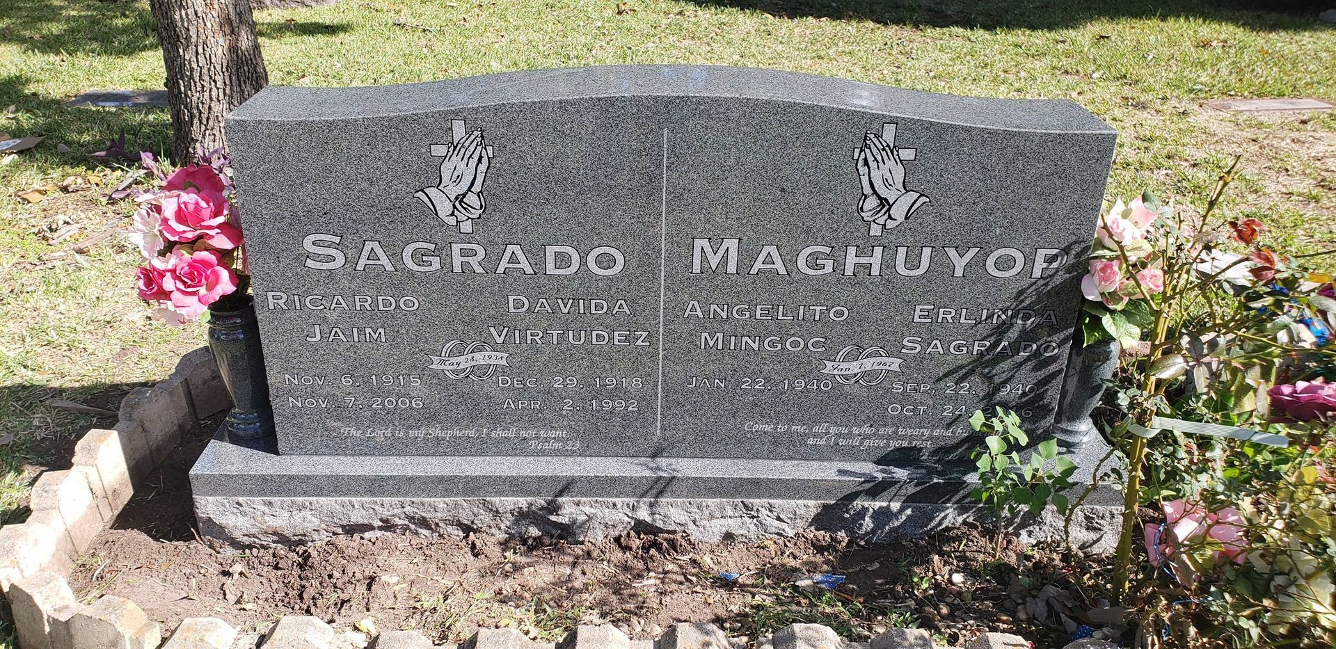 A gravestone in a cemetery with flowers on it.