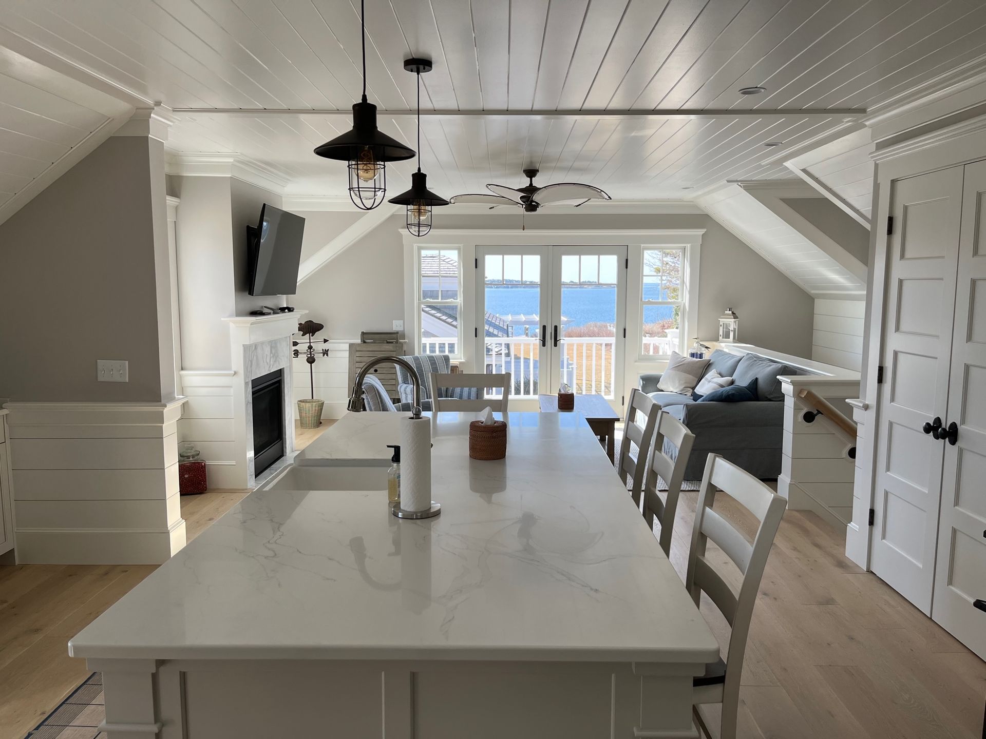 Bright, open kitchen with island, pendant lights, and view of water.