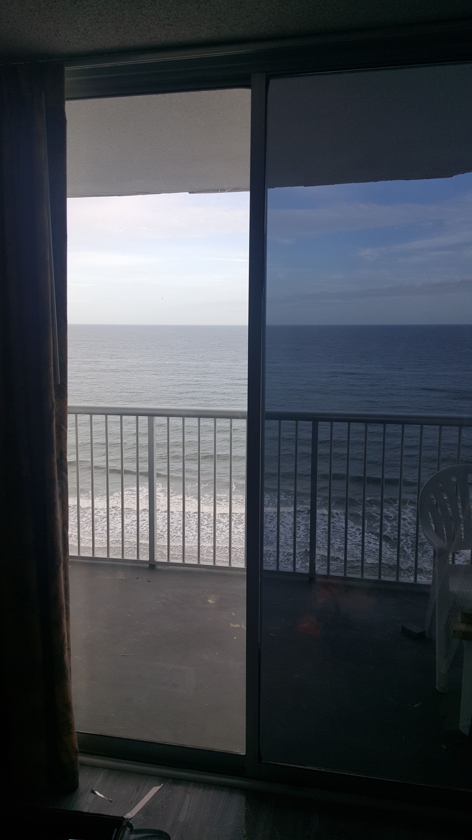 A view of the ocean through a sliding glass door